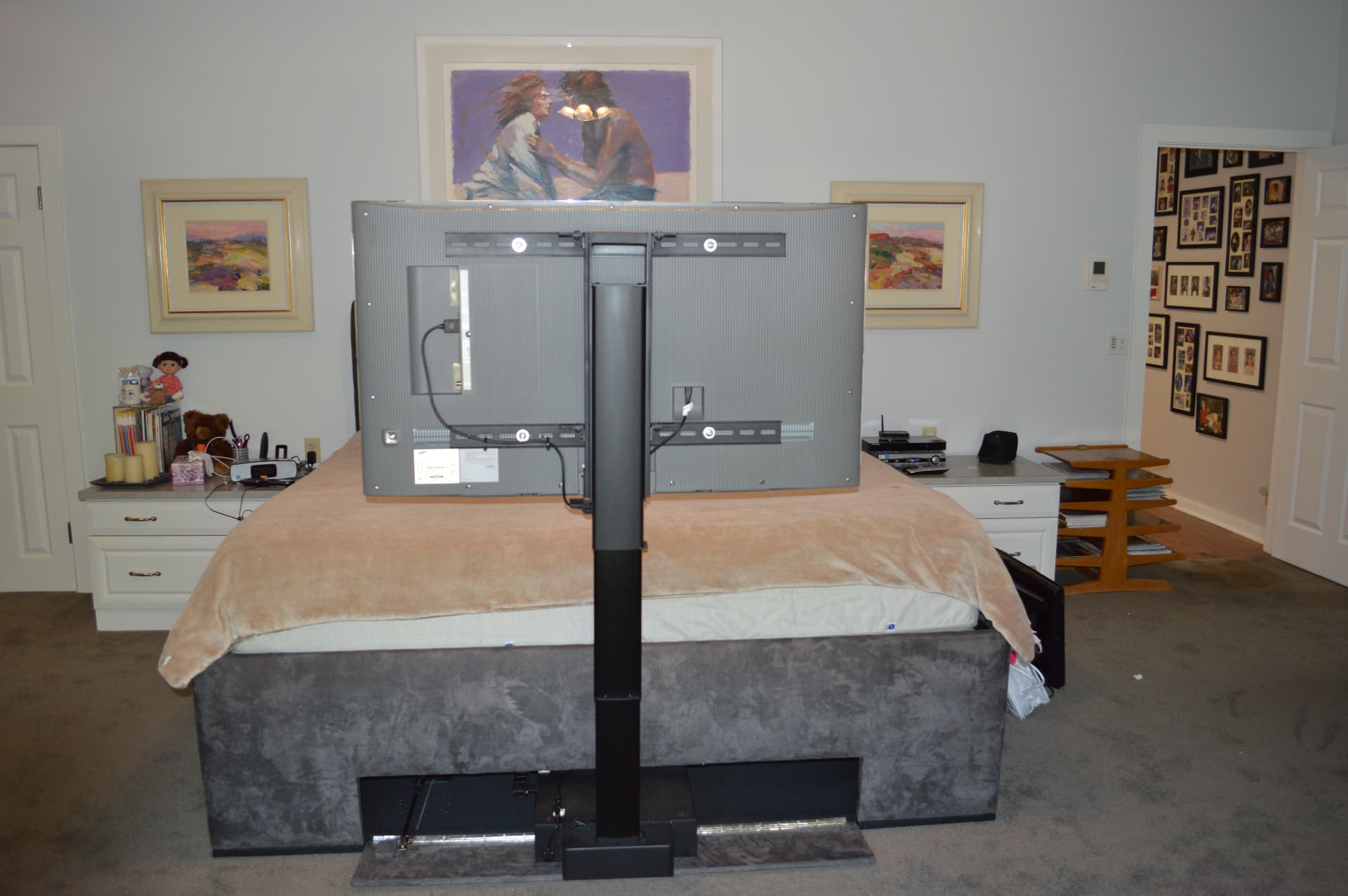 Motorized TV lift at foot of bed showing rear mounting mechanism